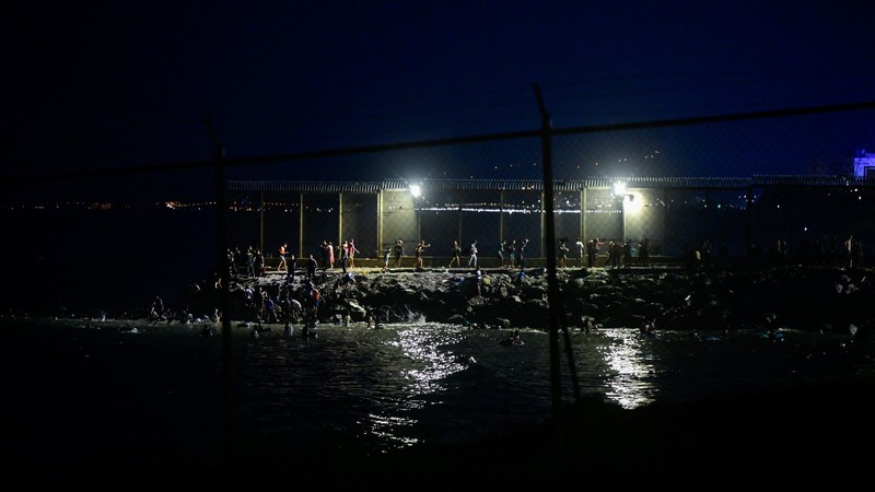 Migrants from Morocco cross into Ceuta by sea and gather near the border fence between the Spanish enclave of Ceuta and Morocco, as seen from Ceuta, Spain, July 30, 2026. REUTERS/Fabian Bimmer