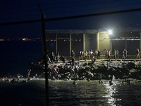 Migrants from Morocco cross into Ceuta by sea and gather near the border fence between the Spanish enclave of Ceuta and Morocco, as seen from Ceuta, Spain, July 30, 2026. REUTERS/Fabian Bimmer