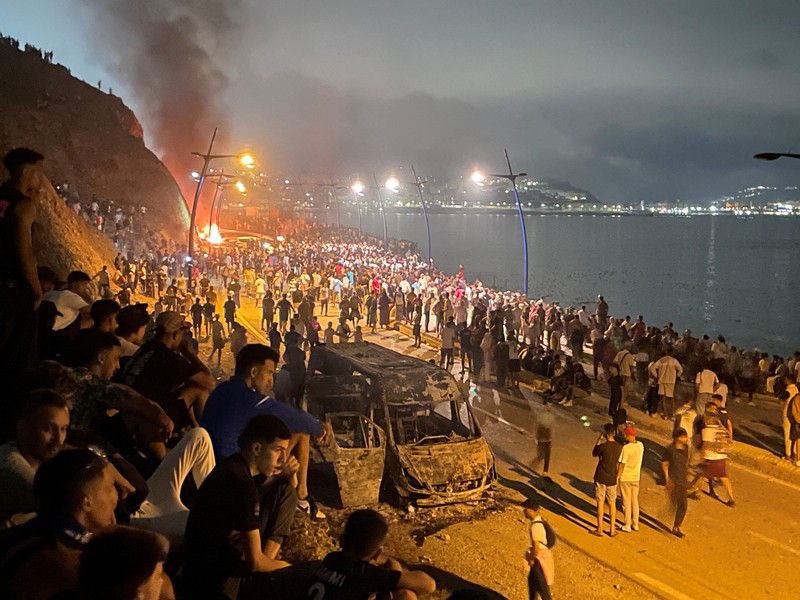 Migrants from Morocco cross into Ceuta by sea and gather near the border fence between the Spanish enclave of Ceuta and Morocco, as seen from Ceuta, Spain, July 30, 2026. REUTERS/Fabian Bimmer