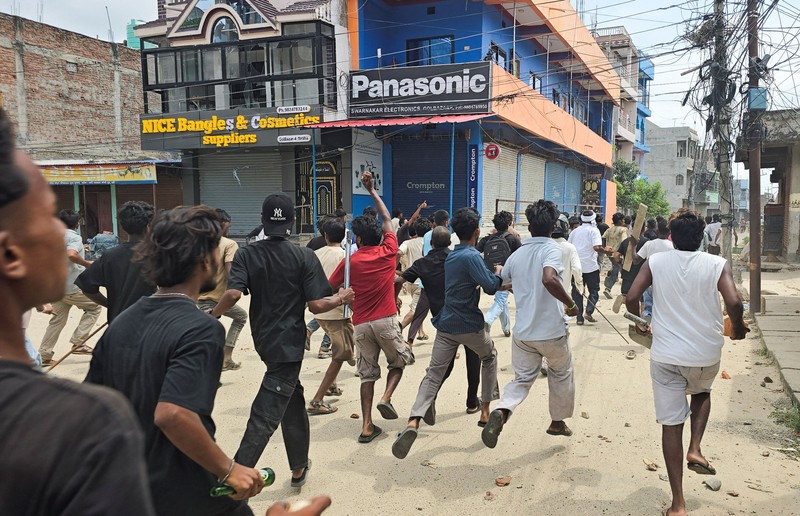 Anggota Pasukan Polisi Bersenjata (APF) mengejar demonstran selama protes menyusul bentrokan antara dua komunitas di Siraha, Nepal, 30 Juli 2026. (REUTERS/Stringer)