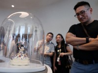 Para tamu melihat-lihat hidangan penutup bertema karakter di toko roti internasional pertama Pop Mart selama acara media day mereka di Resorts World Sentosa di Singapura pada 29 Juli 2026. (REUTERS/Edgar Su)