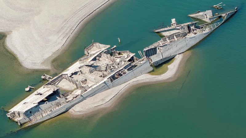 Sebuah tayangan drone menunjukkan orang-orang berenang di dekat kapal perang Jerman yang tenggelam dari Perang Dunia II, yang terlihat karena rendahnya permukaan Sungai Danube akibat kekeringan dan panas ekstrem, di Prahovo, Serbia, 30 Juli 2026. (RE