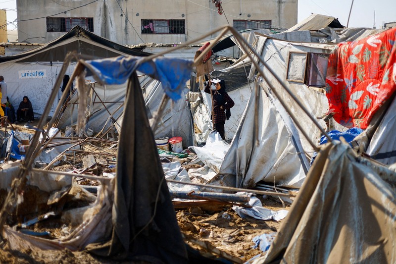 Palestinians inspect the site of an overnight Israeli strike on a medicine warehouse,  according to medics, next to tents sheltering displaced Palestinians, in Deir al-Balah, in the central Gaza Strip, August 1, 2026, residents had been pre-warned by the Israeli military to evacuate. REUTERS/Mahmoud Issa REFILE - ADDS INFORMATION