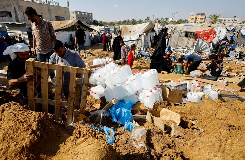 Palestinians inspect the site of an overnight Israeli strike on a medicine warehouse,  according to medics, next to tents sheltering displaced Palestinians, in Deir al-Balah, in the central Gaza Strip, August 1, 2026, residents had been pre-warned by the Israeli military to evacuate. REUTERS/Mahmoud Issa REFILE - ADDS INFORMATION
