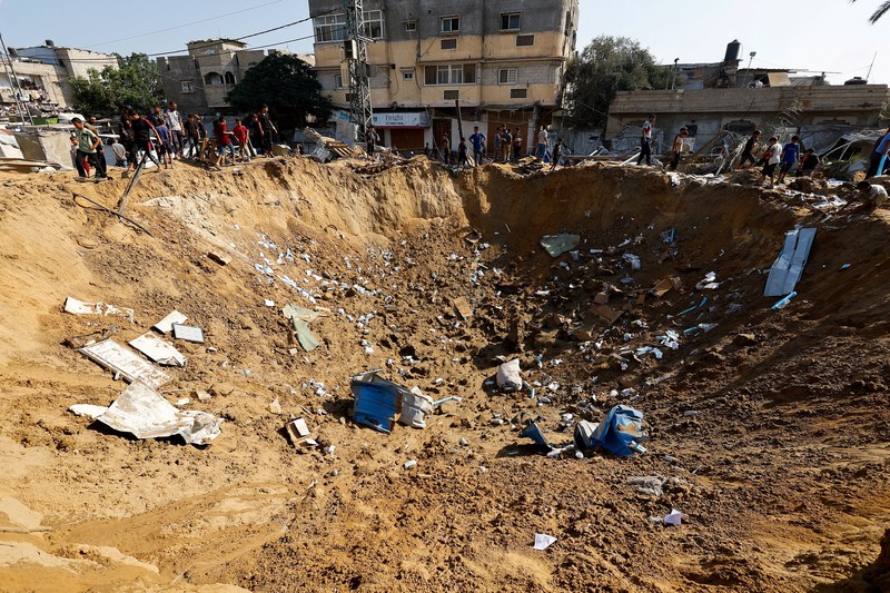 Palestinians inspect the site of an overnight Israeli strike on a medicine warehouse,  according to medics, next to tents sheltering displaced Palestinians, in Deir al-Balah, in the central Gaza Strip, August 1, 2026, residents had been pre-warned by the Israeli military to evacuate. REUTERS/Mahmoud Issa REFILE - ADDS INFORMATION