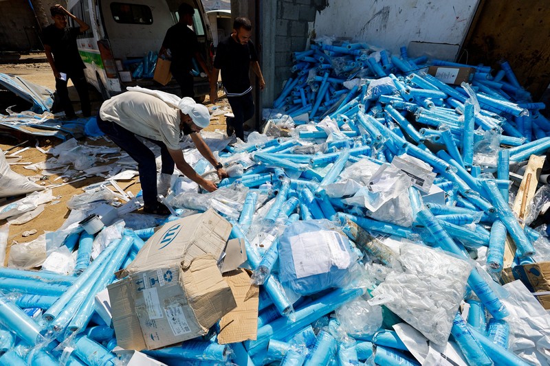 Palestinians inspect the site of an overnight Israeli strike on a medicine warehouse,  according to medics, next to tents sheltering displaced Palestinians, in Deir al-Balah, in the central Gaza Strip, August 1, 2026, residents had been pre-warned by the Israeli military to evacuate. REUTERS/Mahmoud Issa REFILE - ADDS INFORMATION