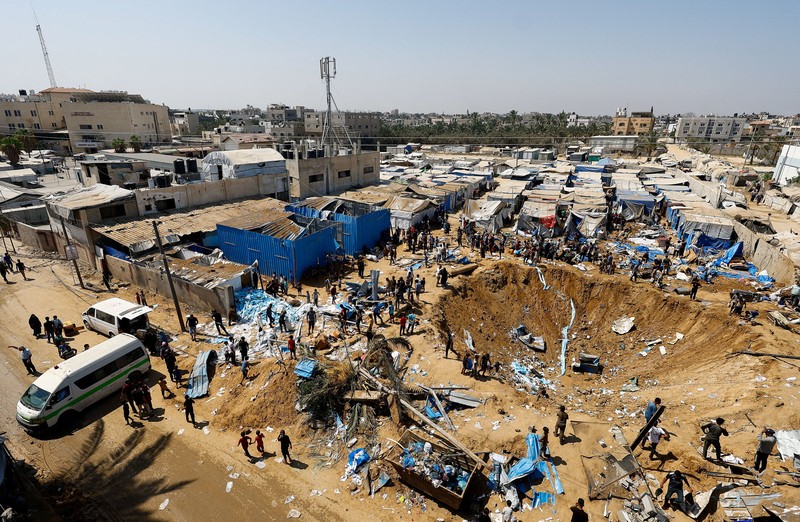 Palestinians inspect the site of an overnight Israeli strike on a medicine warehouse,  according to medics, next to tents sheltering displaced Palestinians, in Deir al-Balah, in the central Gaza Strip, August 1, 2026, residents had been pre-warned by the Israeli military to evacuate. REUTERS/Mahmoud Issa REFILE - ADDS INFORMATION