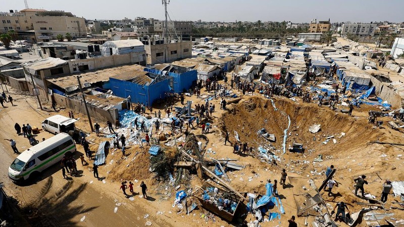 Palestinians inspect the site of an overnight Israeli strike on a medicine warehouse,  according to medics, next to tents sheltering displaced Palestinians, in Deir al-Balah, in the central Gaza Strip, August 1, 2026, residents had been pre-warned by