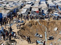 Palestinians inspect the site of an overnight Israeli strike on a medicine warehouse,  according to medics, next to tents sheltering displaced Palestinians, in Deir al-Balah, in the central Gaza Strip, August 1, 2026, residents had been pre-warned by