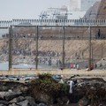 Migrants walk on the Moroccan side of the border, after mass crossings of migrants on foot and by sea from Morocco into Spanish territory, as seen from Cueta, Spain, August 1, 2026. REUTERS/Jon Nazca