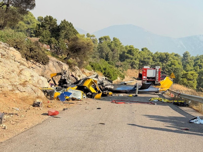 Seorang warga menyaksikan sebuah helikopter menjatuhkan air saat kebakaran hutan melanda lembah Megara, Yunani, 2 Agustus 2026. (REUTERS/Louisa Gouliamaki)