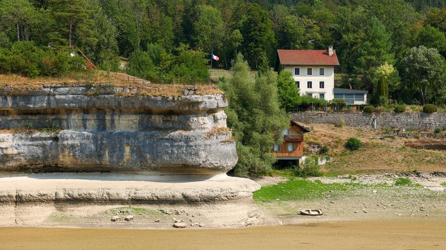 Sebuah bendera Prancis terlihat berkibar di tebing di Danau Brenet yang hampir kosong, karena kondisi kekeringan yang melanda Sungai Doubs menurunkan permukaan air di perbatasan Swiss-Prancis di Les Brenets, Swiss, 30 Juli 2026.