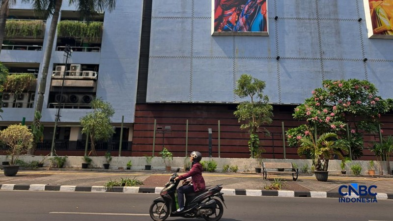 Warga melintas di samping pagar Blok M Plaza, Jakarta, Senin (3/8/2026). Polemik pemasangan pagar tinggi di sejumlah pusat perbelanjaan di Jakarta mencuri perhatian setelah beberapa mal memasang pagar besi yang mengelilingi area bangunan.