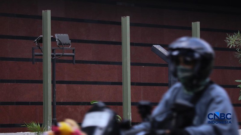 Warga melintas di samping pagar Blok M Plaza, Jakarta, Senin (3/8/2026). Polemik pemasangan pagar tinggi di sejumlah pusat perbelanjaan di Jakarta mencuri perhatian setelah beberapa mal memasang pagar besi yang mengelilingi area bangunan. (CNBC Indon