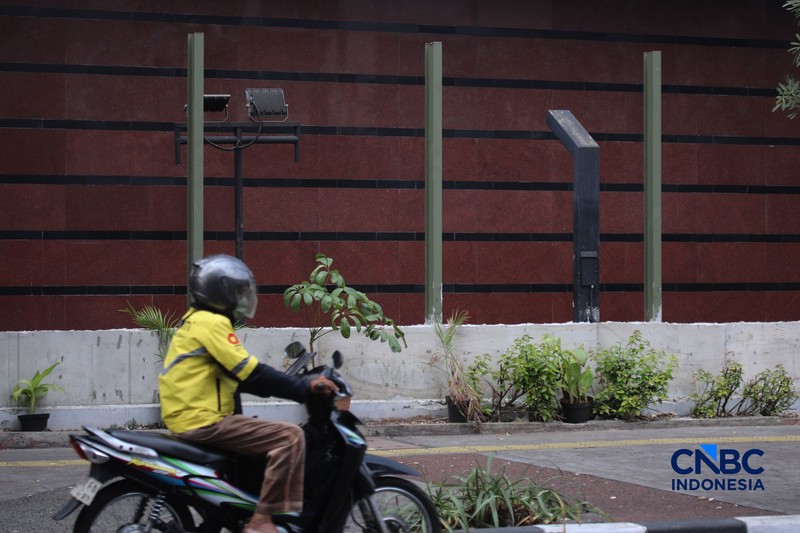 Warga melintas di samping pagar Blok M Plaza, Jakarta, Senin (3/8/2026). Polemik pemasangan pagar tinggi di sejumlah pusat perbelanjaan di Jakarta mencuri perhatian setelah beberapa mal memasang pagar besi yang mengelilingi area bangunan. (CNBC Indonesia/Faisal Rahman)