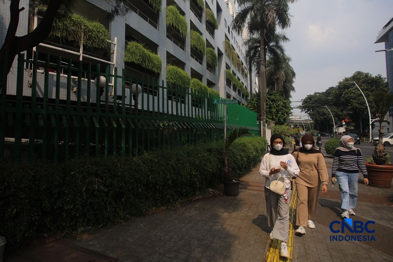 Warga melintas di samping pagar Blok M Plaza, Jakarta, Senin (3/8/2026). Polemik pemasangan pagar tinggi di sejumlah pusat perbelanjaan di Jakarta mencuri perhatian setelah beberapa mal memasang pagar besi yang mengelilingi area bangunan. (CNBC Indonesia/Faisal Rahman)