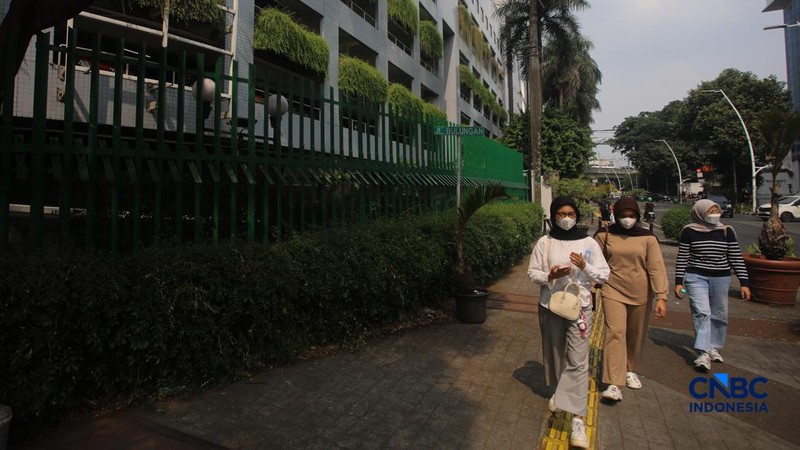 Warga melintas di samping pagar Blok M Plaza, Jakarta, Senin (3/8/2026). Polemik pemasangan pagar tinggi di sejumlah pusat perbelanjaan di Jakarta mencuri perhatian setelah beberapa mal memasang pagar besi yang mengelilingi area bangunan. (CNBC Indon