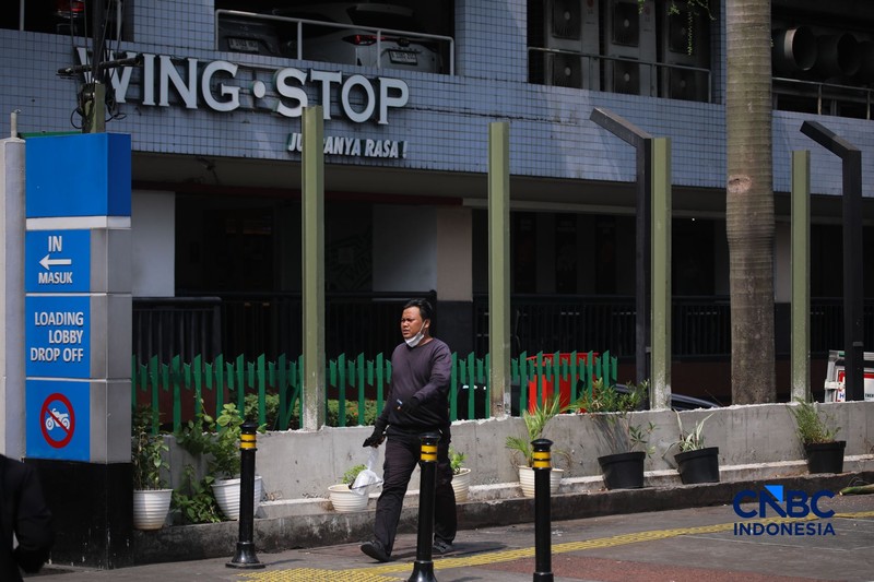 Warga melintas di samping pagar Blok M Plaza, Jakarta, Senin (3/8/2026). Polemik pemasangan pagar tinggi di sejumlah pusat perbelanjaan di Jakarta mencuri perhatian setelah beberapa mal memasang pagar besi yang mengelilingi area bangunan. (CNBC Indonesia/Faisal Rahman)