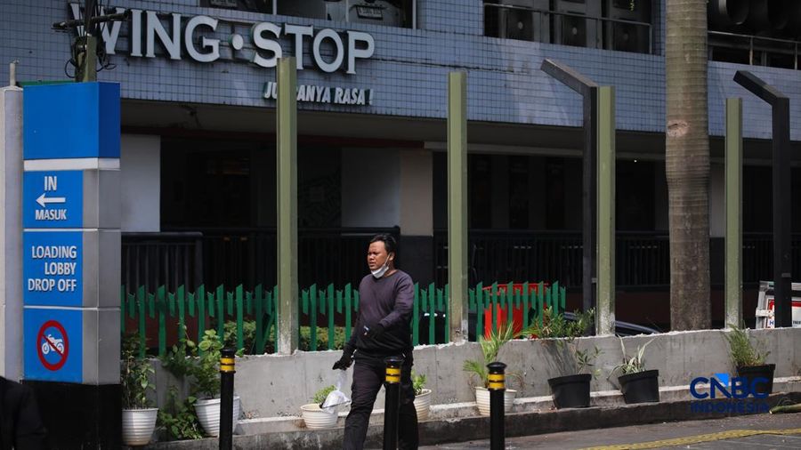 Warga melintas di samping pagar Blok M Plaza, Jakarta, Senin (3/8/2026). Polemik pemasangan pagar tinggi di sejumlah pusat perbelanjaan di Jakarta mencuri perhatian setelah beberapa mal memasang pagar besi yang mengelilingi area bangunan. (CNBC Indon