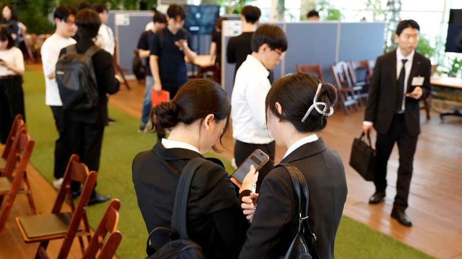Para pencari kerja Korea Selatan melihat ponsel pintar bersama-sama selama pameran kerja yang menghubungkan pelamar dengan pemberi kerja Jepang di Seoul, Korea Selatan, 12 Juli 2026.