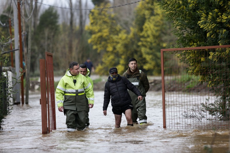Nancy Badilla berjalan di sepanjang jalan yang tergenang air setelah badai membawa hujan lebat dan menyebabkan banjir di Angol, Chili, 3 Agustus 2026. (REUTERS/Juan Gonzalez)