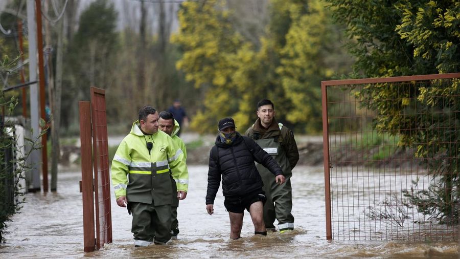 Petugas polisi (Carabineros) membantu seorang penduduk setelah angin besar membawa hujan lebat dan menyebabkan banjir di Concepcion, Chili, 2 Agustus 2026.