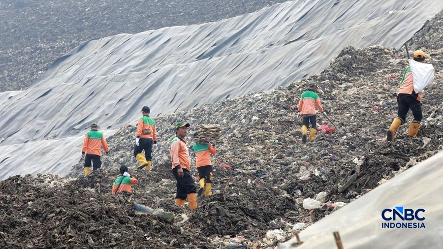 Sejumlah petugas TPST Bantargebang memasang lapisan geomembran di tempat pemrosesan atau pembuangan akhir (TPA) sampah Bantargebang, Bekasi, Jawa Barat, Selasa, (4/8/2026). (CNBC Indonesia/Muhammad Sabki)