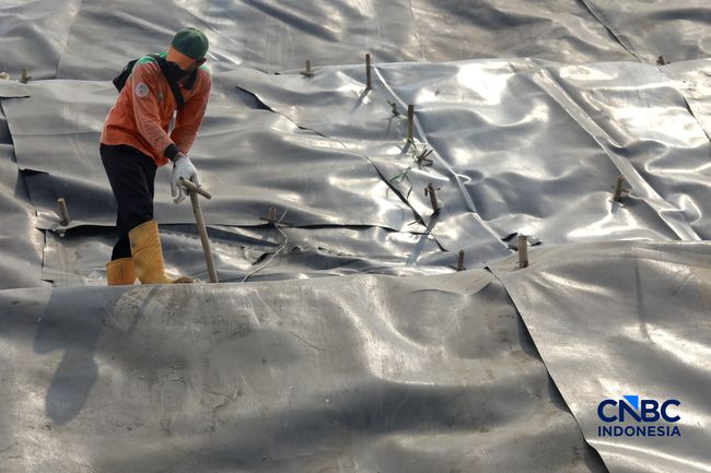 Sejumlah petugas TPST Bantar Gebang memasang lapisan geomembran di tempat pemrosesan atau pembuangan akhir (TPA) sampah Bantargebang, Bekasi, Jawa Barat, Selasa, (4/8/2026). (CNBC Indonesia/Muhammad Sabki)