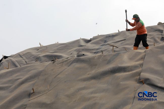 Sejumlah petugas TPST Bantar Gebang memasang lapisan geomembran di tempat pemrosesan atau pembuangan akhir (TPA) sampah Bantargebang, Bekasi, Jawa Barat, Selasa, (4/8/2026). (CNBC Indonesia/Muhammad Sabki)