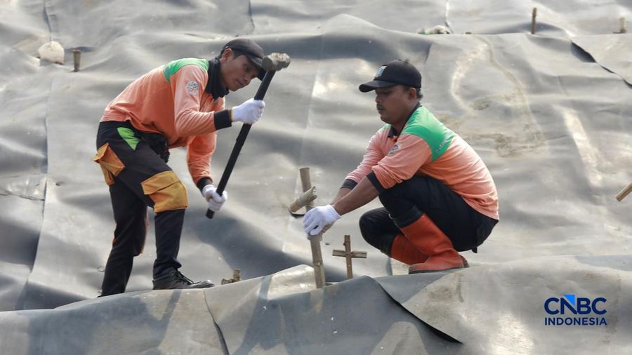 Sejumlah petugas TPST Bantar Gebang memasang lapisan geomembran di tempat pemrosesan atau pembuangan akhir (TPA) sampah Bantargebang, Bekasi, Jawa Barat, Selasa, (4/8/2026). (CNBC Indonesia/Muhammad Sabki)