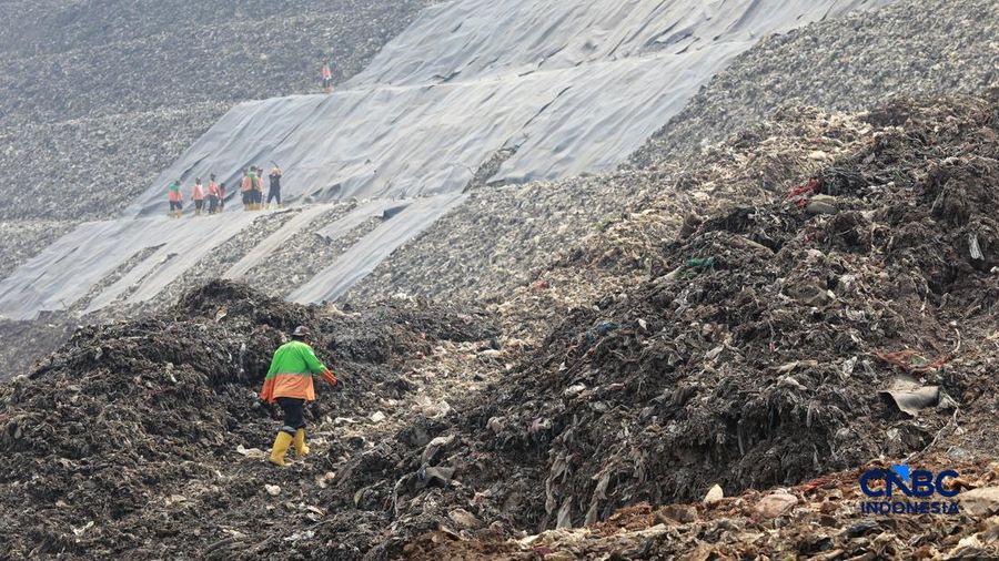 Sejumlah petugas TPST Bantargebang memasang lapisan geomembran di tempat pemrosesan atau pembuangan akhir (TPA) sampah Bantargebang, Bekasi, Jawa Barat, Selasa, (4/8/2026). (CNBC Indonesia/Muhammad Sabki)