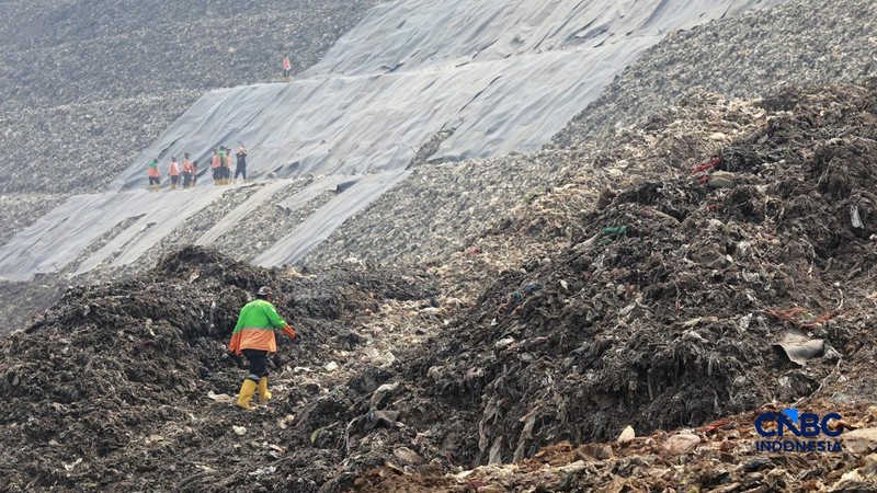 Sejumlah petugas TPST Bantargebang memasang lapisan geomembran di tempat pemrosesan atau pembuangan akhir (TPA) sampah Bantargebang, Bekasi, Jawa Barat, Selasa, (4/8/2026). (CNBC Indonesia/Muhammad Sabki)