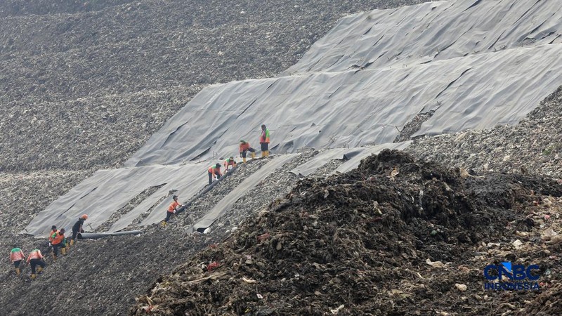 Sejumlah petugas TPST Bantargebang memasang lapisan geomembran di tempat pemrosesan atau pembuangan akhir (TPA) sampah Bantargebang, Bekasi, Jawa Barat, Selasa, (4/8/2026). (CNBC Indonesia/Muhammad Sabki)