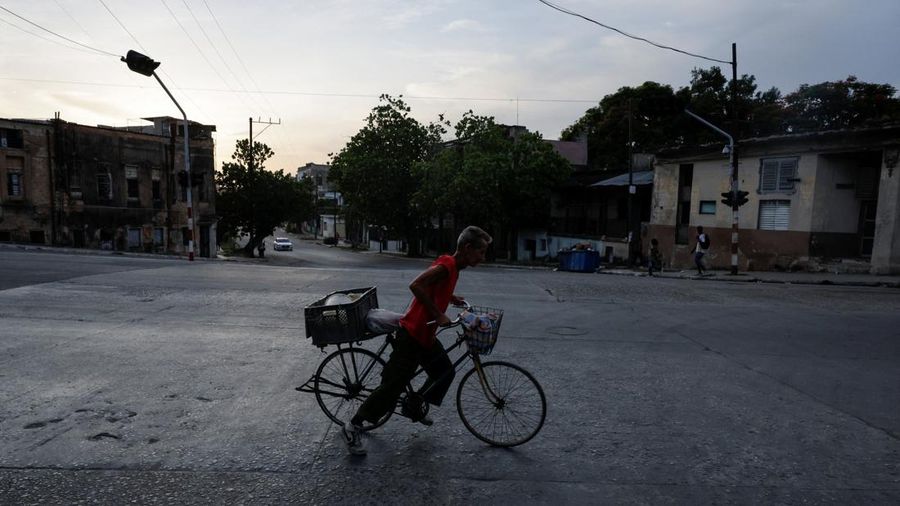 Seorang laki-laki mengendarai sepeda sembari menyeberang jalan saat jaringan listrik nasional Kuba mengalami gangguan pada hari Minggu, kegagalan jaringan listrik nasional keempat dalam waktu kurang dari sebulan, di Havana, Kuba, 3 Agustus 2026. (REUTERS/N
