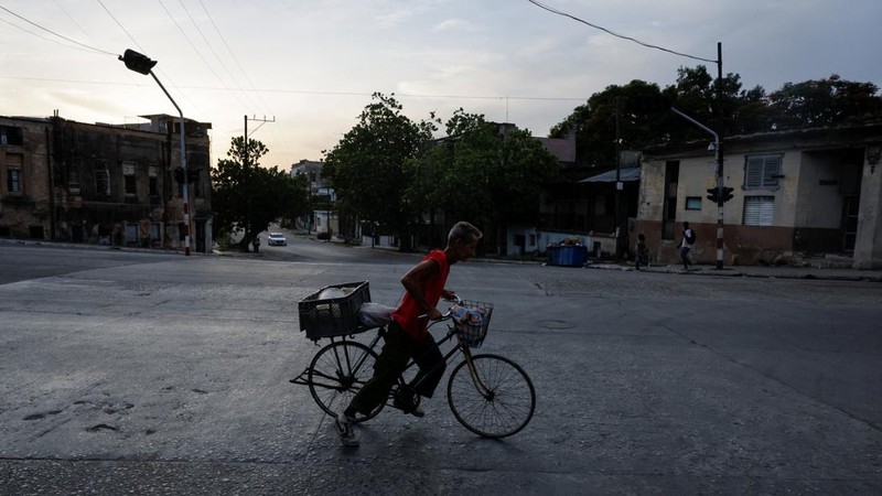 Seorang pria mengendarai sepeda sambil menyeberang jalan saat jaringan listrik nasional Kuba mengalami gangguan pada hari Minggu, kegagalan jaringan listrik nasional keempat dalam waktu kurang dari sebulan, di Havana, Kuba, 3 Agustus 2026. (REUTERS/N