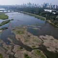 Sebuah pemandangan dari drone memperlihatkan cakrawala Warsawa di balik hamparan pasir yang muncul ke permukaan di Sungai Vistula, saat gelombang panas menyebabkan penurunan permukaan air sungai di beberapa wilayah negara tersebut, di Warsawa, Poland