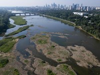 Sebuah pemandangan dari drone memperlihatkan cakrawala Warsawa di balik hamparan pasir yang muncul ke permukaan di Sungai Vistula, saat gelombang panas menyebabkan penurunan permukaan air sungai di beberapa wilayah negara tersebut, di Warsawa, Poland