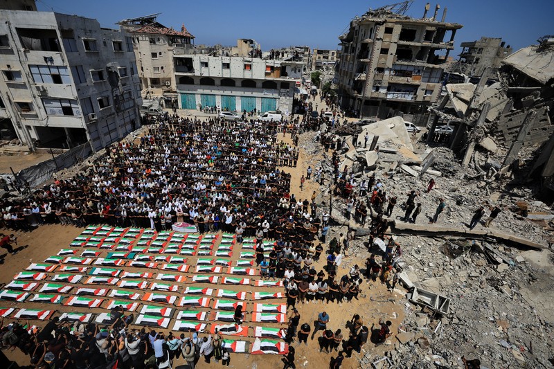Warga Gaza menggelar pemakaman jenazah 112 anggota satu keluarga besar yang tewas dalam agresi Israel hampir tiga tahun lalu, Selasa (4/8/2026). (via REUTERS/Dawoud Abu Alkas)