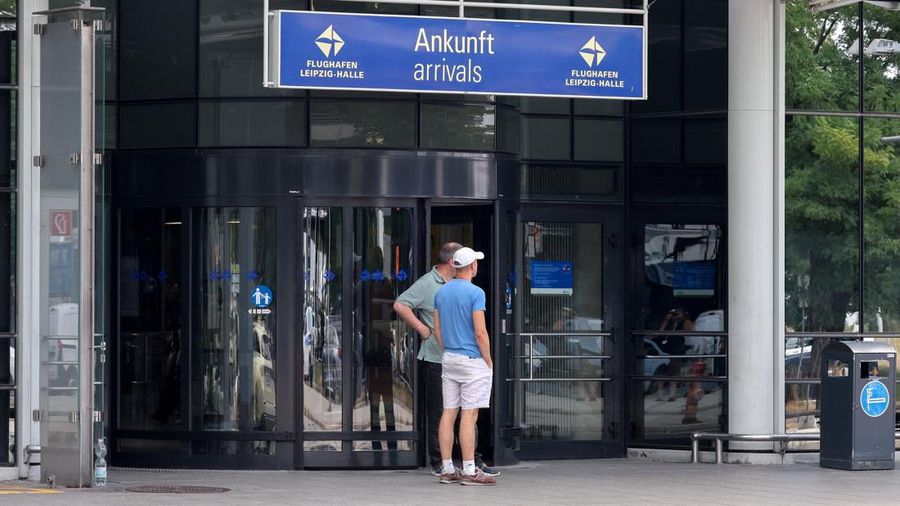 Orang-orang berdiri di luar area kedatangan Bandara Leipzig/Halle di Schkeuditz, Jerman, pada 5 Agustus 2026, setelah polisi menyatakan bahwa ahli bahan peledak telah memeriksa sebuah drone yang ditemukan di dekat landasan pacu, serta setelah sebuah pesawat kargo DHL menabrak objek tak dikenal saat sedang menanjak meninggalkan bandara pada malam sebelumnya, yang memicu pendaratan tak terjadwal di Hanover, menurut sumber yang mengetahui insiden tersebut.