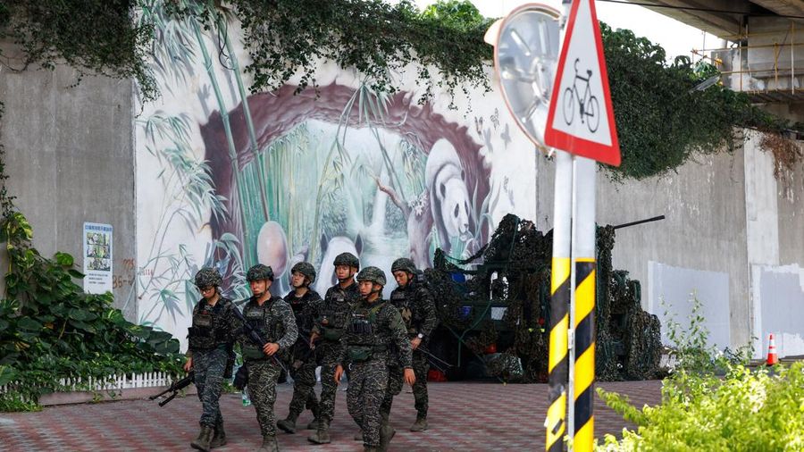 Para tentara berjalan melewati kendaraan militer saat latihan militer tahunan Han Kuang di Taipei, Taiwan, 6 Agustus 2026. (REUTERS/Ann Wang)