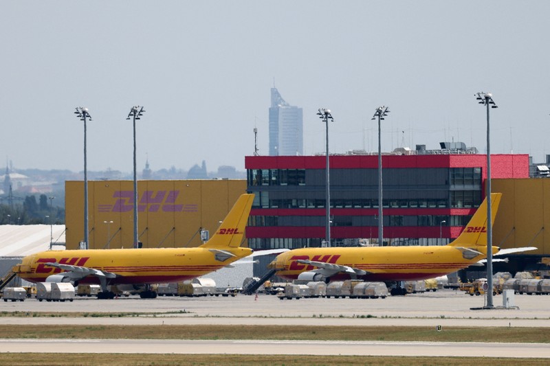 Pesawat-pesawat kargo DHL terparkir di Bandara Leipzig/Halle, Schkeuditz, Jerman, Rabu (5/8/2026), setelah polisi mengerahkan ahli bahan peledak untuk memeriksa sebuah pesawat nirawak (drone) yang ditemukan di dekat landasan pacu. Pemeriksaan dilakukan menyusul insiden sebuah pesawat kargo DHL yang menabrak objek tak dikenal sesaat setelah lepas landas pada malam sebelumnya hingga terpaksa melakukan pendaratan tak terjadwal di Hanover, menurut sumber yang mengetahui insiden tersebut. (REUTERS/Axel Schmidt)