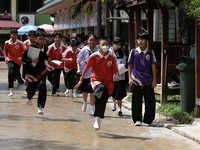 Para siswa berlari saat mengevakuasi diri dari Sekolah Debsirin Nonthaburi—lokasi terjadinya insiden penembakan—di Distrik Bang Kruai, Provinsi Nonthaburi, di pinggiran Bangkok, Thailand, pada 7 Agustus 2026. (REUTERS/Chalinee Thirasupa)