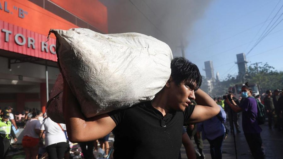 Seorang laki-laki membawa peralatan dagangan keluar dari pasar Feria Barrio Lindo setelah pasar tersebut terbakar pada malam sebelumnya, di Santa Cruz, Bolivia, 6 Agustus 2026.