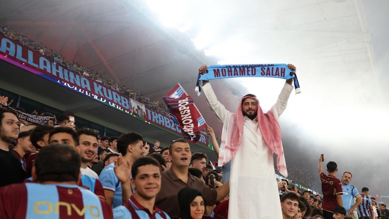 Seorang suporter Trabzonspor memperlihatkan syal bergambar Mohamed Salah di dalam Stadion Papara Park, Trabzon, Turki, Kamis (6/8/2026).