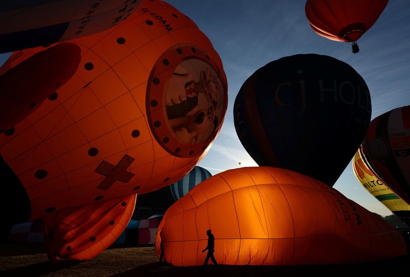 Warga menyaksikan balon udara terbang saat peluncuran massal di acara tahunan Bristol International Balloon Fiesta di Bristol, Inggris, pada 8 Agustus 2026. (REUTERS/Toby Melville)