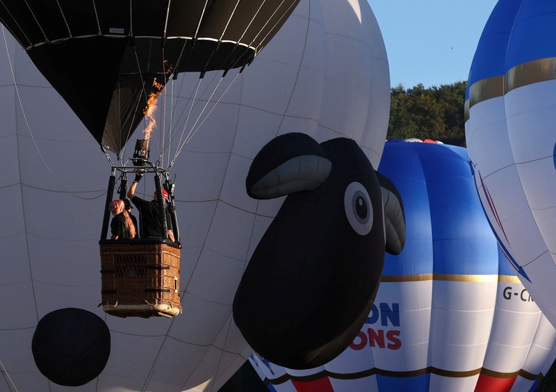Warga menyaksikan balon udara terbang saat peluncuran massal di acara tahunan Bristol International Balloon Fiesta di Bristol, Inggris, pada 8 Agustus 2026. (REUTERS/Toby Melville)