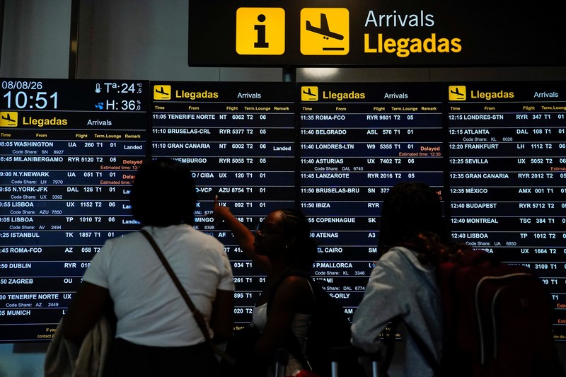 Petugas kepolisian nasional Spanyol memantau kedatangan para pelancong dari Italia di Bandara Madrid-Barajas, Madrid, Spanyol, pada 8 Agustus 2026, setelah pemerintah Spanyol mengumumkan akan memberlakukan pemeriksaan perbatasan untuk penerbangan dan kapal dari Italia&mdash;mulai tengah malam hari Sabtu hingga 7 September&mdash;di tengah sengketa mengenai migrasi ilegal. (Spanish Police/Handout via REUTERS)