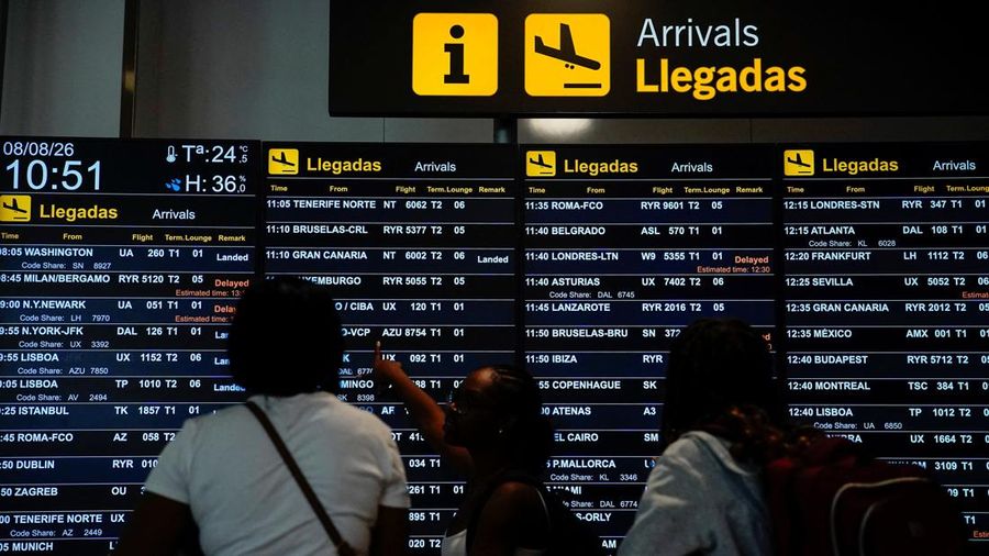 Orang-orang melihat papan informasi yang menampilkan rincian penerbangan di Bandara Adolfo Suarez Madrid–Barajas, Madrid, Spanyol, pada 8 Agustus 2026, saat pemerintah Spanyol menyatakan akan memberlakukan pemeriksaan perbatasan bagi penerbangan dan kapal dari Italia—mulai tengah malam hari Sabtu hingga 7 September—di tengah perselisihan mengenai migrasi ilegal.