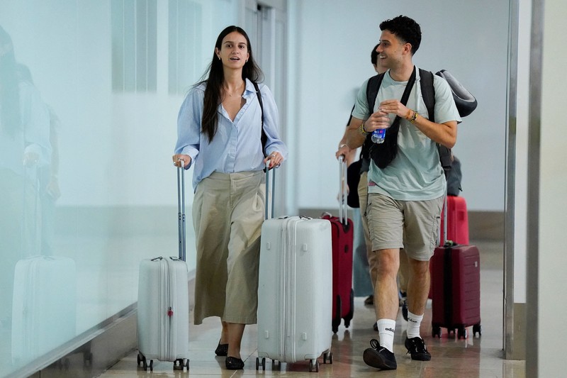 Petugas kepolisian nasional Spanyol memantau kedatangan para pelancong dari Italia di Bandara Madrid-Barajas, Madrid, Spanyol, pada 8 Agustus 2026, setelah pemerintah Spanyol mengumumkan akan memberlakukan pemeriksaan perbatasan untuk penerbangan dan kapal dari Italia&mdash;mulai tengah malam hari Sabtu hingga 7 September&mdash;di tengah sengketa mengenai migrasi ilegal. (Spanish Police/Handout via REUTERS)