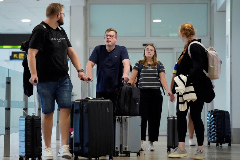 Petugas kepolisian nasional Spanyol memantau kedatangan para pelancong dari Italia di Bandara Madrid-Barajas, Madrid, Spanyol, pada 8 Agustus 2026, setelah pemerintah Spanyol mengumumkan akan memberlakukan pemeriksaan perbatasan untuk penerbangan dan kapal dari Italia&mdash;mulai tengah malam hari Sabtu hingga 7 September&mdash;di tengah sengketa mengenai migrasi ilegal. (Spanish Police/Handout via REUTERS)